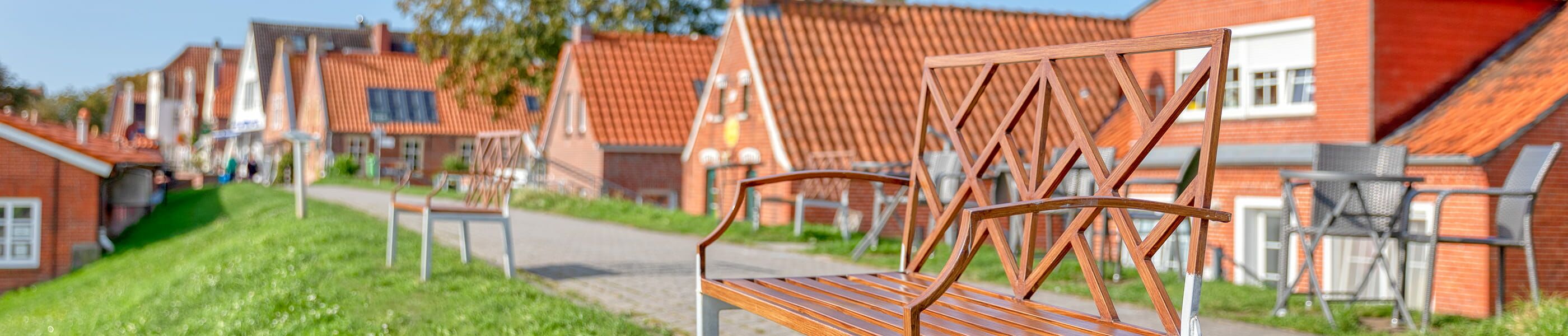 Bank entlang eines Weges mit Historischen Häusern in Greetsiel