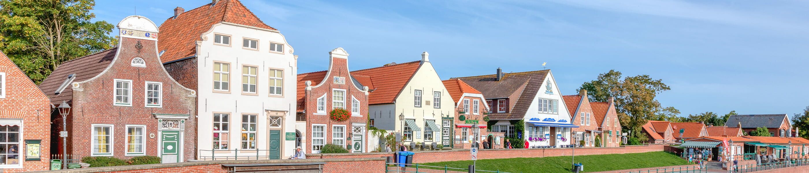 Historische Giebelhäuser in Greetsiel entlang des Deichs